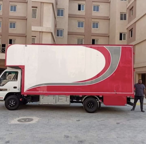 شاحنة نقل أثاث MD Transport الحمراء مجهزة ومغلقة أمام مبنى سكني في القاهرة